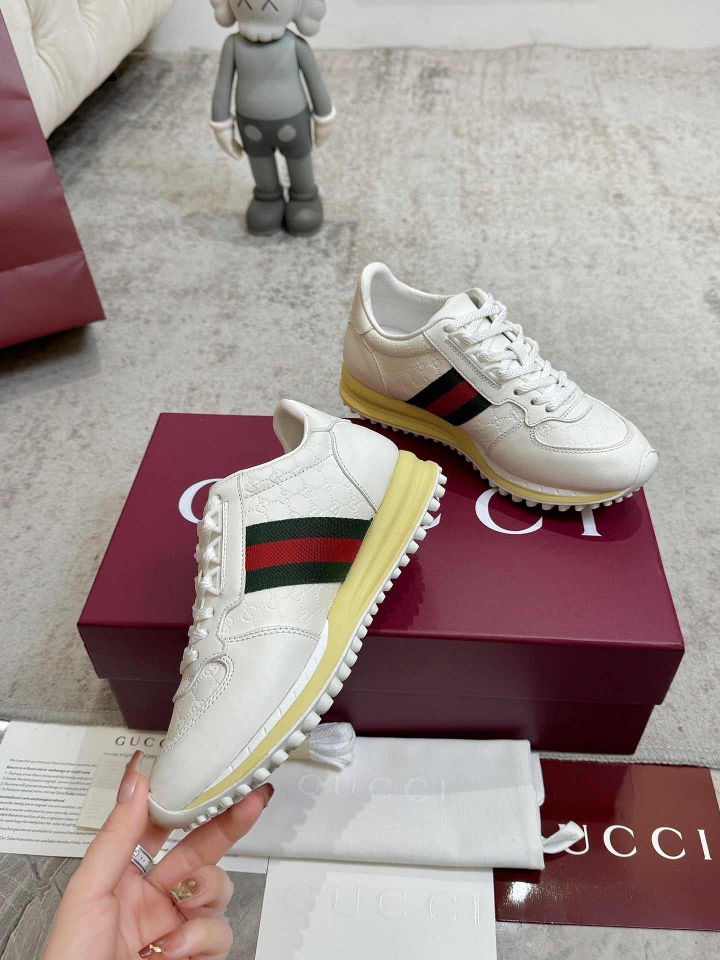 White Gucci leather sneakers with green-red stripe, lace-up style, yellow rubber sole