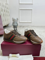 Tan unisex sneakers with green-red stripe, dark laces, and low profile sole