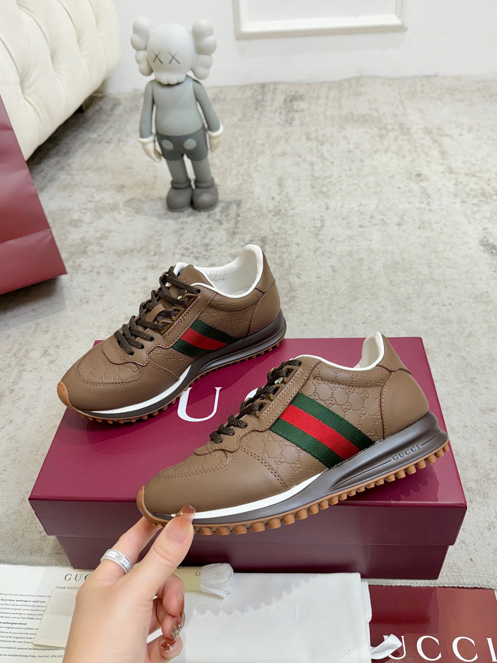 Tan unisex sneakers with green-red web stripe, lace-up front, and rubber tread