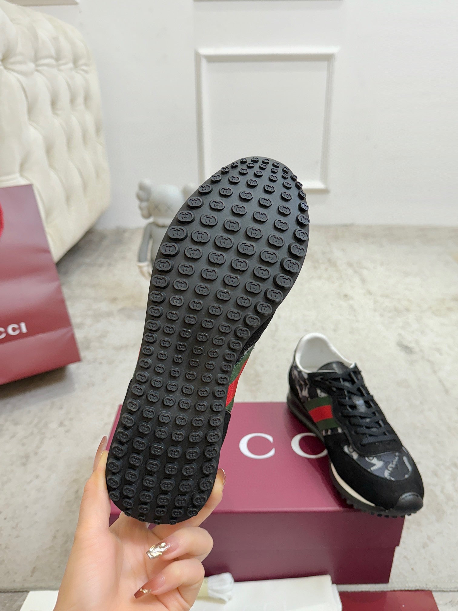 Black sneaker outsole with raised circular tread pattern.
