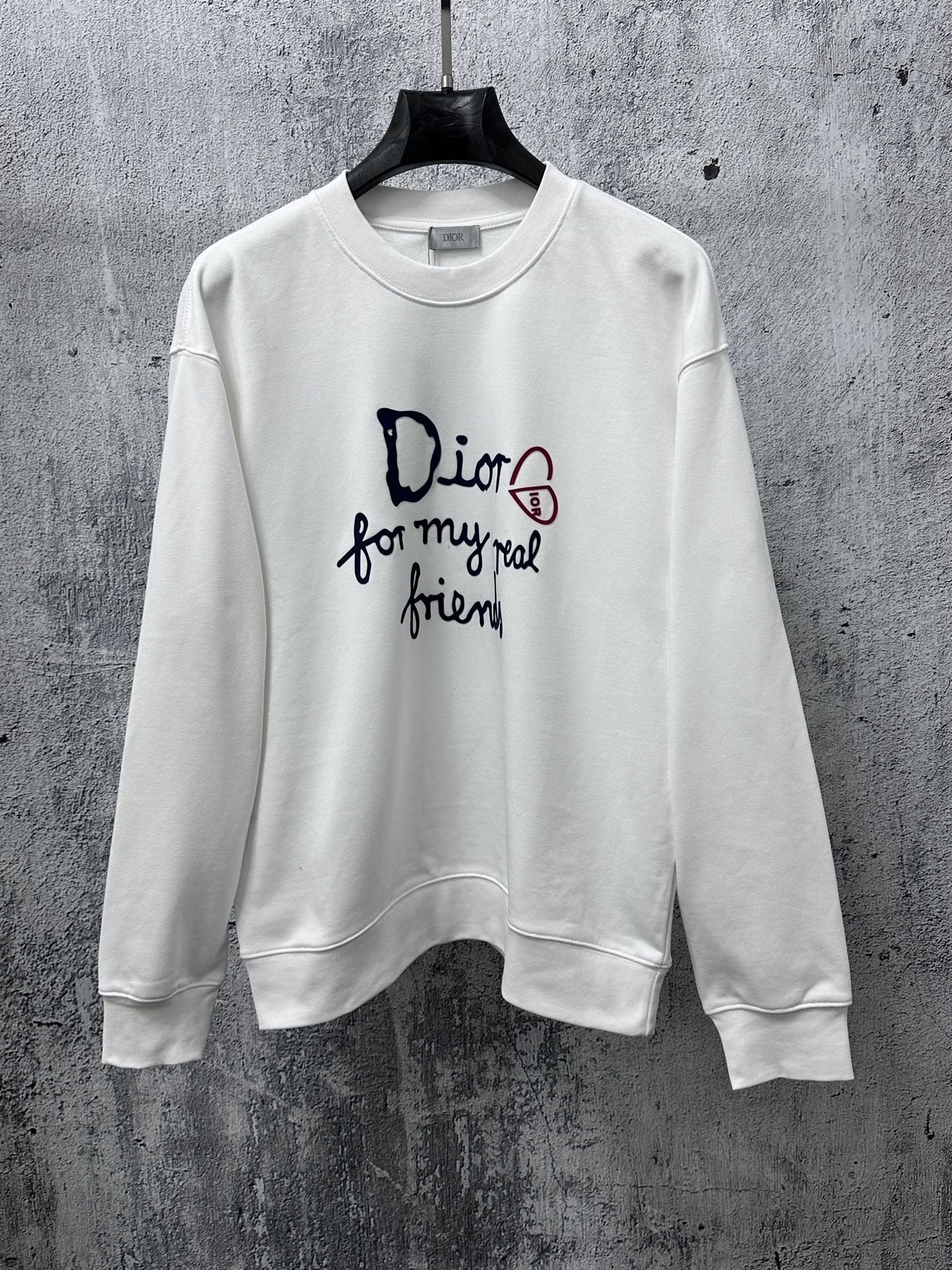 White long-sleeve sweatshirt with Dior logo and text graphic on chest