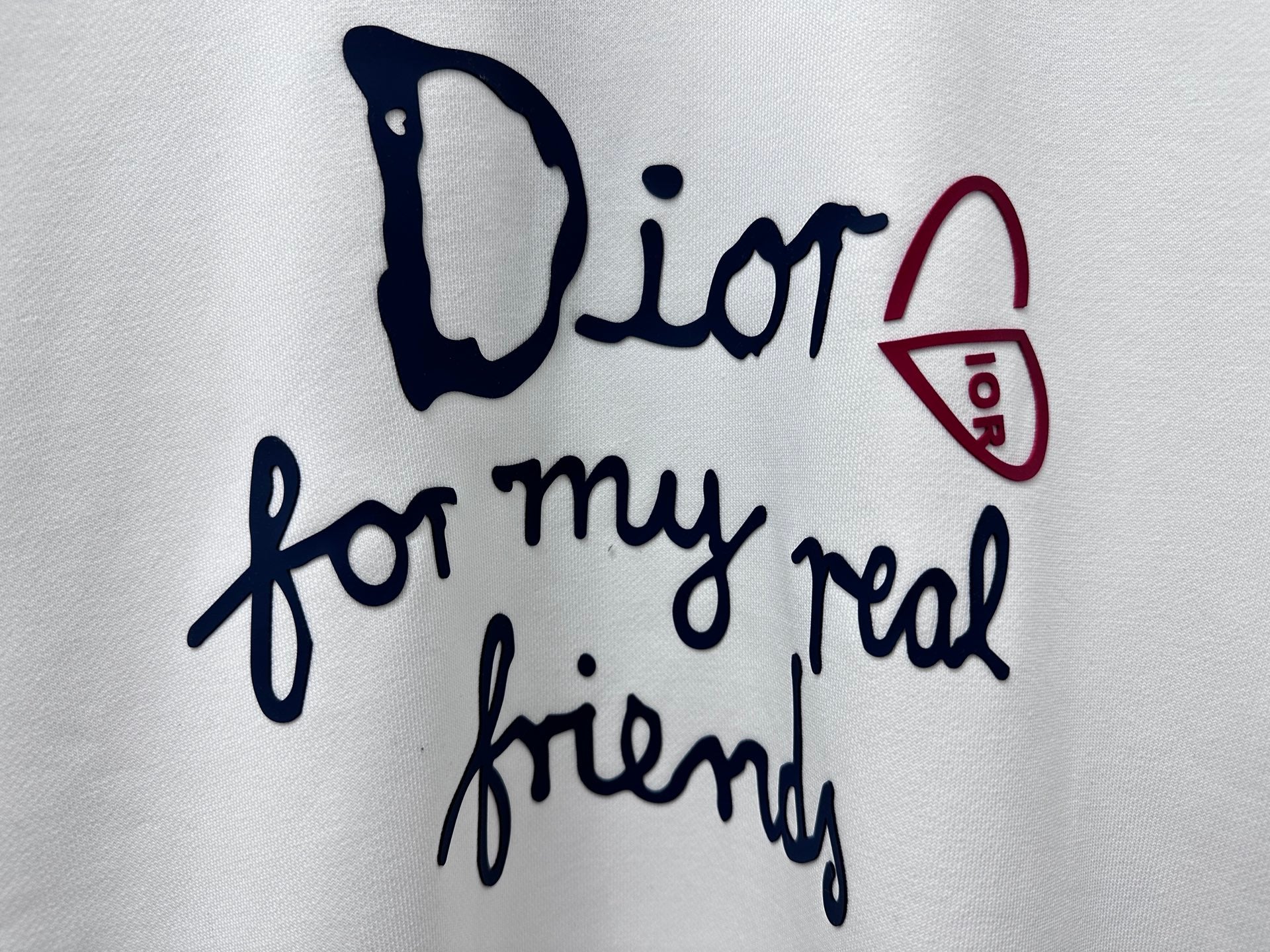 White sweatshirt chest close-up: Dior script and 'for my real friends' graphic
