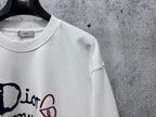 White sweatshirt neckline close-up with Dior tag and partial logo graphic