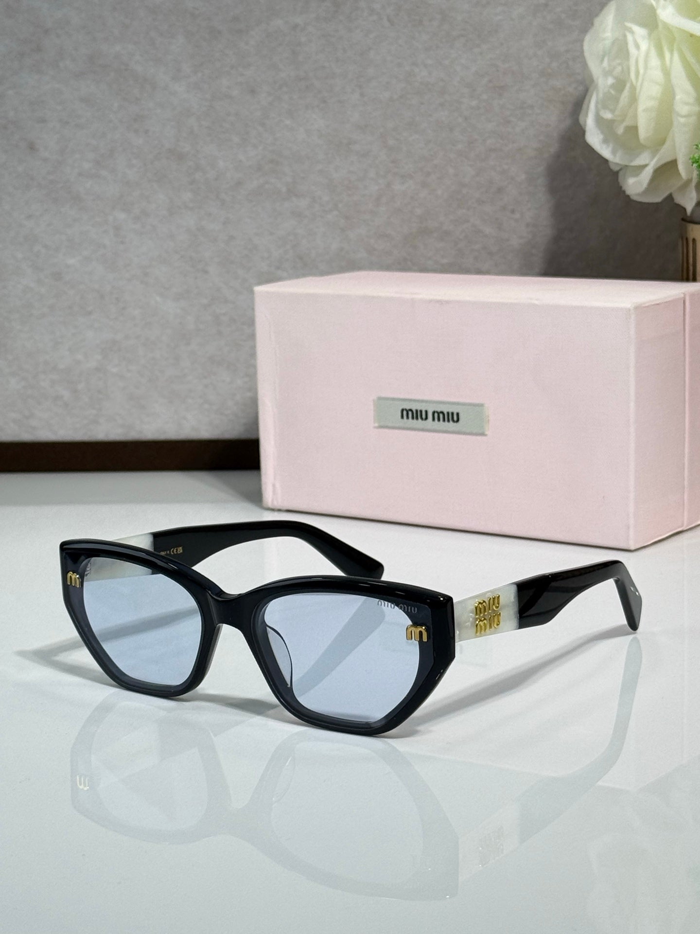 Black sunglasses with tinted lenses and pink logo case