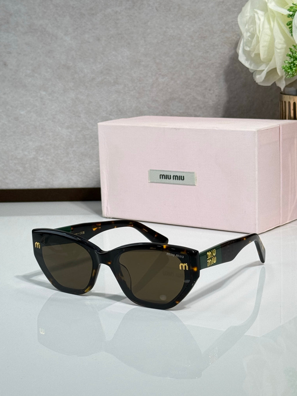 Black sunglasses with dark lenses and pink logo case