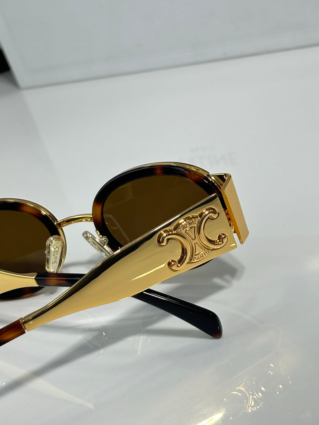 Celine gold oval glasses with dark brown lenses and ornate temple emblem