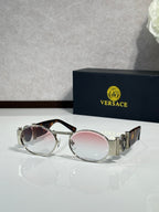 Versace sunglasses with round lenses, silver frame and pink tinted lenses.