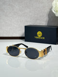 Versace sunglasses with round lenses, gold frame and dark blue tint.