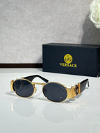 Versace sunglasses with round lenses, gold frame and dark blue tint.