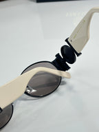 Versace sunglasses close-up of temple and round dark lenses in white and black.