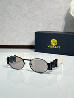 Versace sunglasses with round lenses, white frame with dark arms and dark lenses.