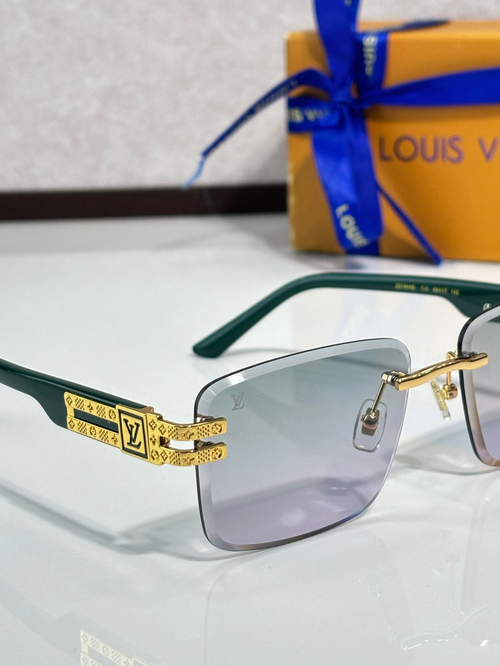 Louis Vuitton sunglasses with green frames and light lenses, gold-tone temples