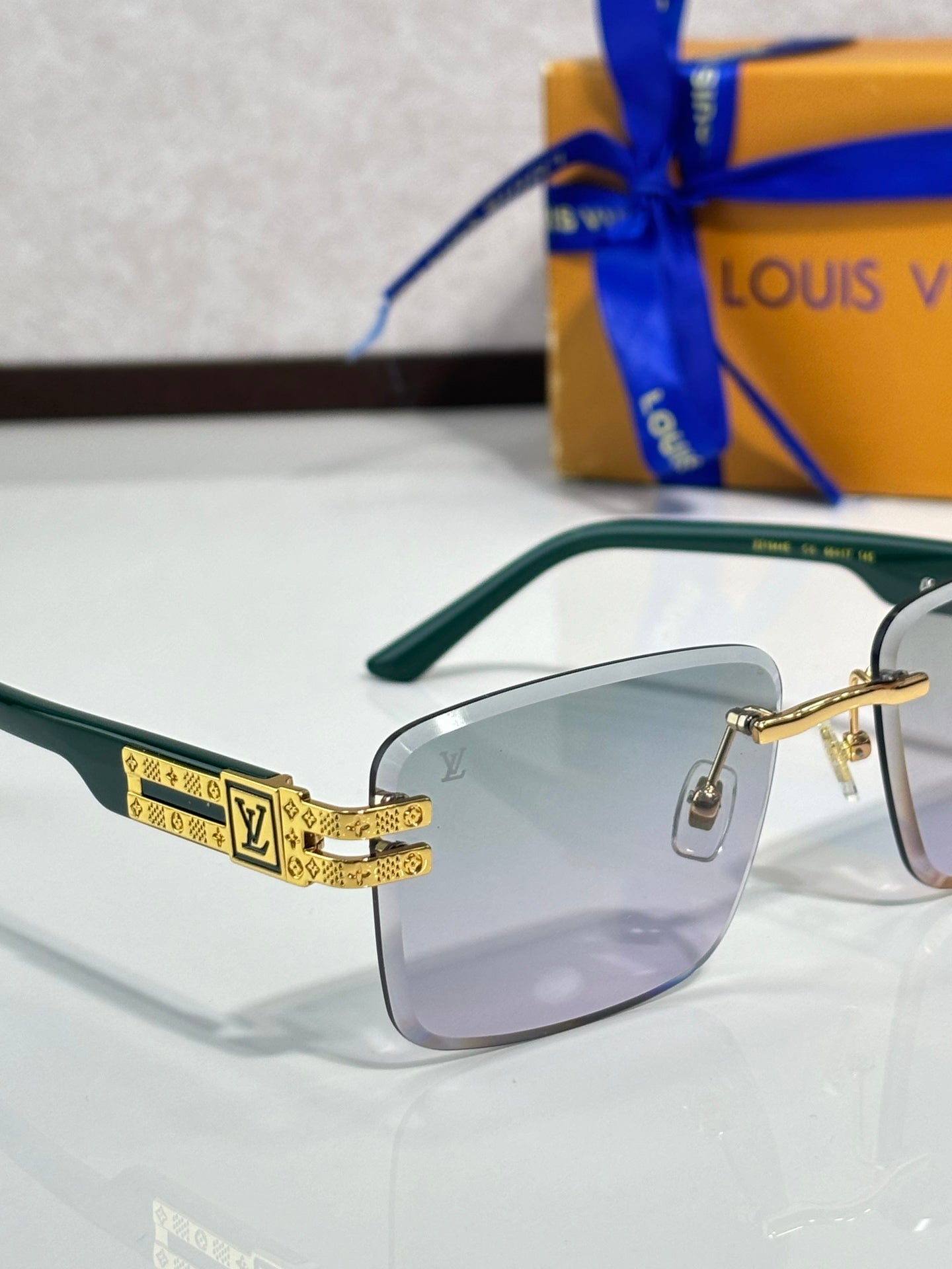 Louis Vuitton sunglasses with green frames and light lenses, gold-tone temples