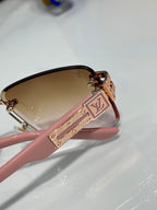 Louis Vuitton sunglasses close-up with pink frame and LV logo detail