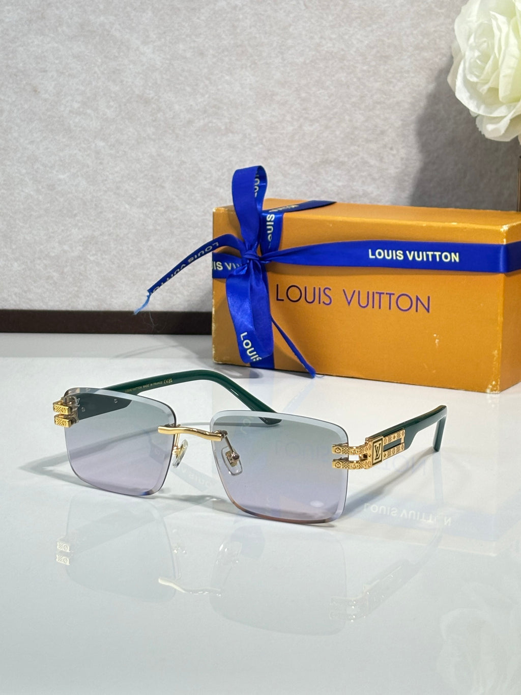 Louis Vuitton sunglasses with green-tinted frames and pale lenses