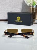 Amber-tinted rectangular sunglasses with gold-tone frame and tortoise temples, shown folded