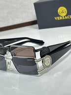 Black rectangular eyeglasses with small logo lens detail and round medallion on the temple