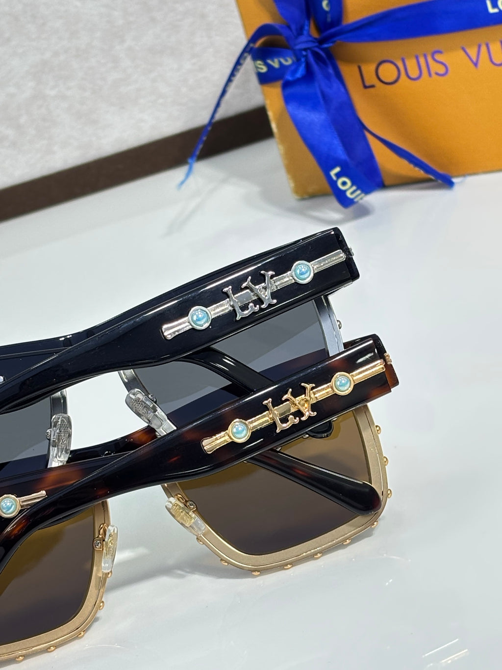 Louis Vuitton sunglasses with ornate gold-tone temple hardware and tinted lenses