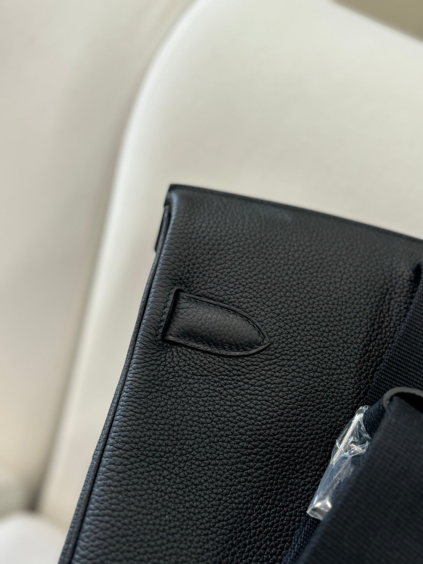 Hermes pebbled leather flap bag close-up of stitched flap corner in dark black
