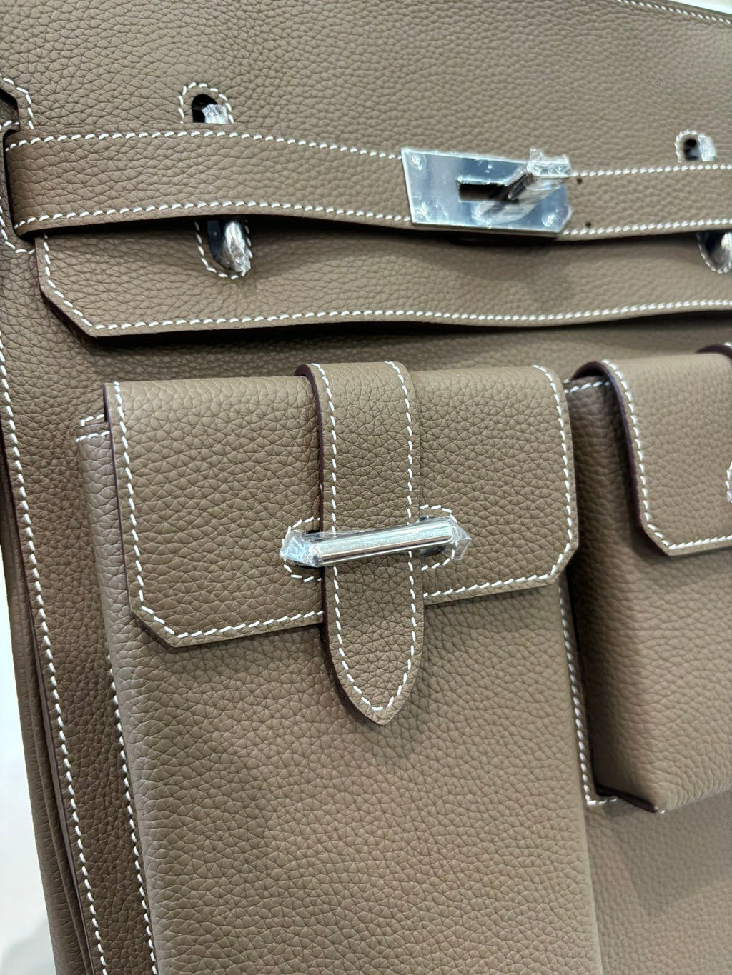 Hermes bag taupe leather front double-pocket flap with metal closure and stitched trim