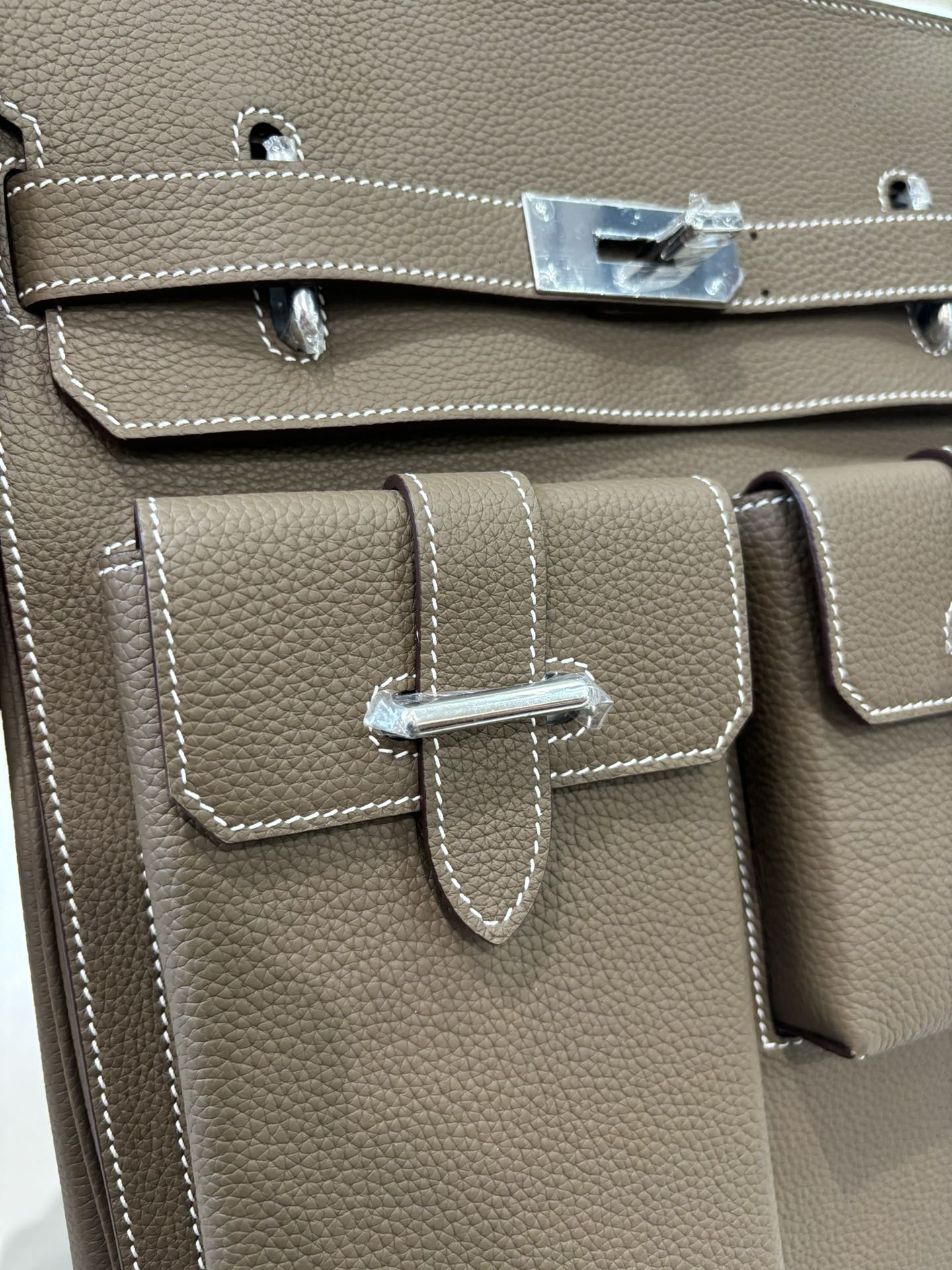 Hermes bag taupe leather front double-pocket flap with metal closure and stitched trim
