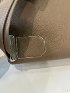 Hermes bag taupe leather corner with stitched trim and small side hardware detail