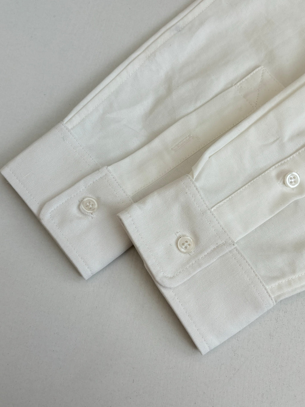 White long-sleeve shirt cuff with two buttons and buttonholes