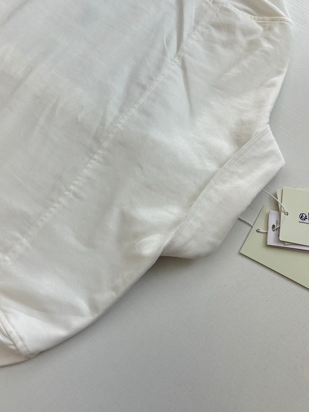 White long-sleeve shirt with stitched panel detail on the front