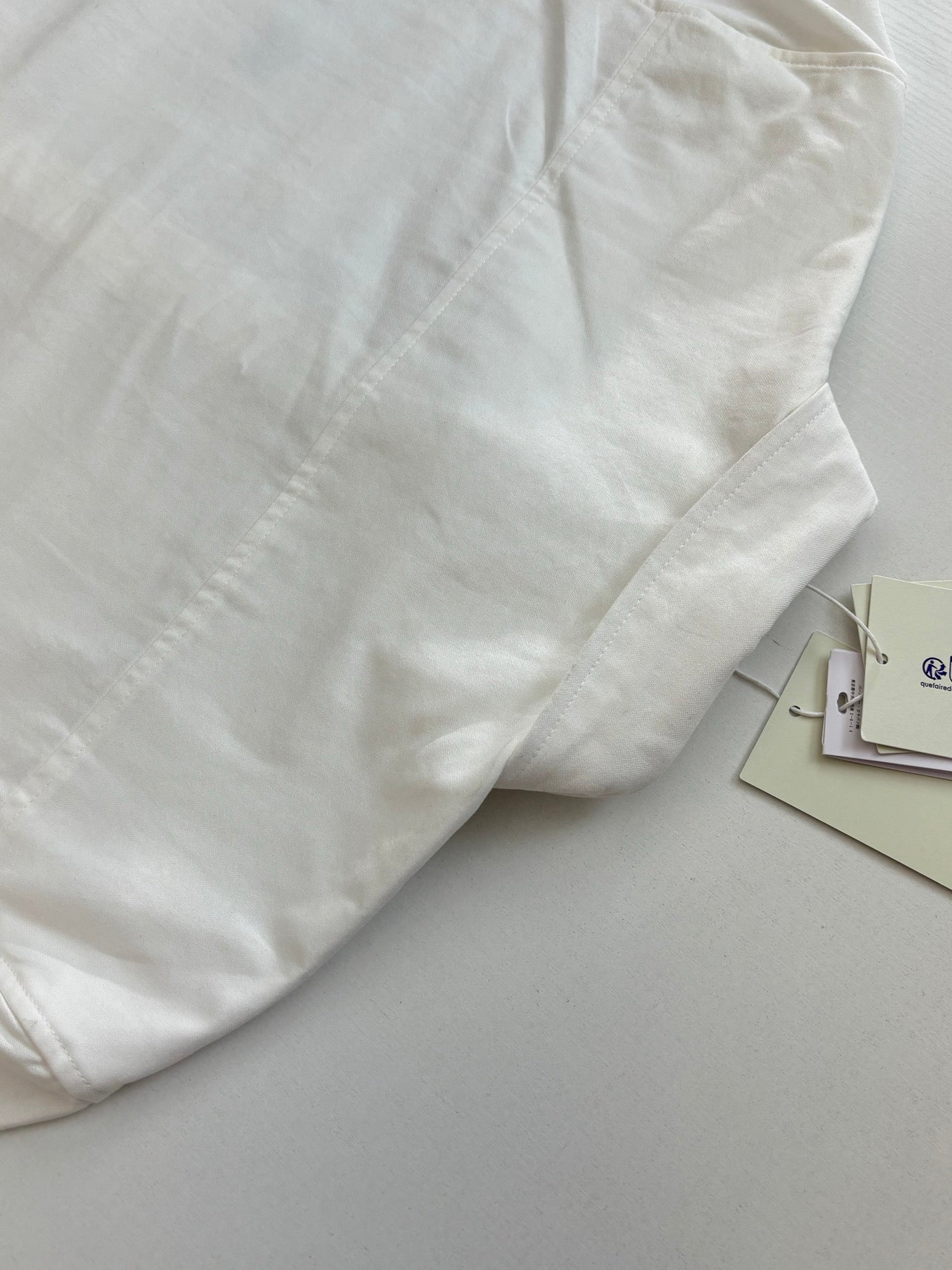 White long-sleeve shirt with stitched panel detail on the front
