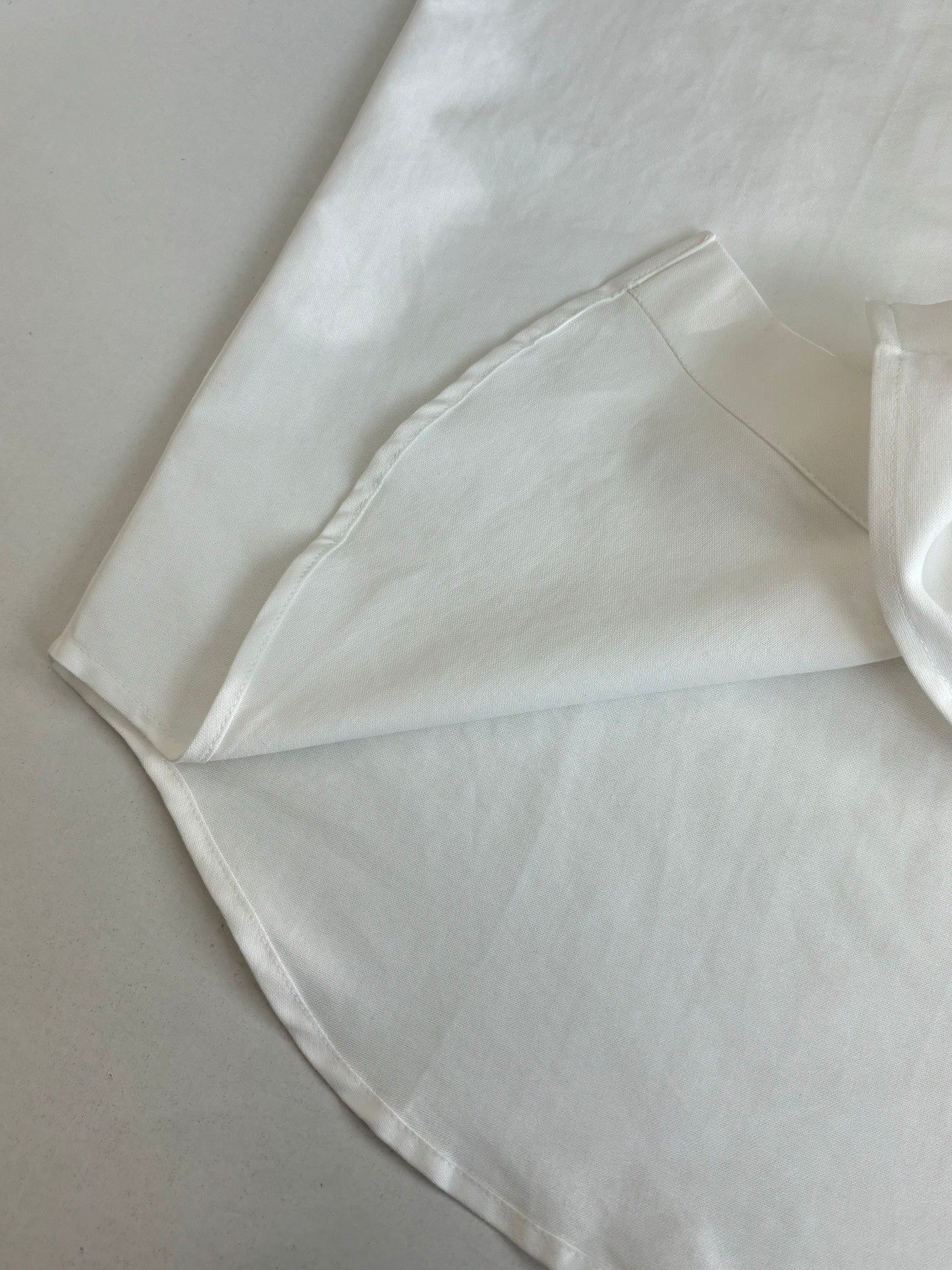 White long-sleeve shirt cuff with stitched seam and folded edge