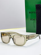 Bottega Veneta sunglasses with smoky frames, light lenses, and gold patterned temples