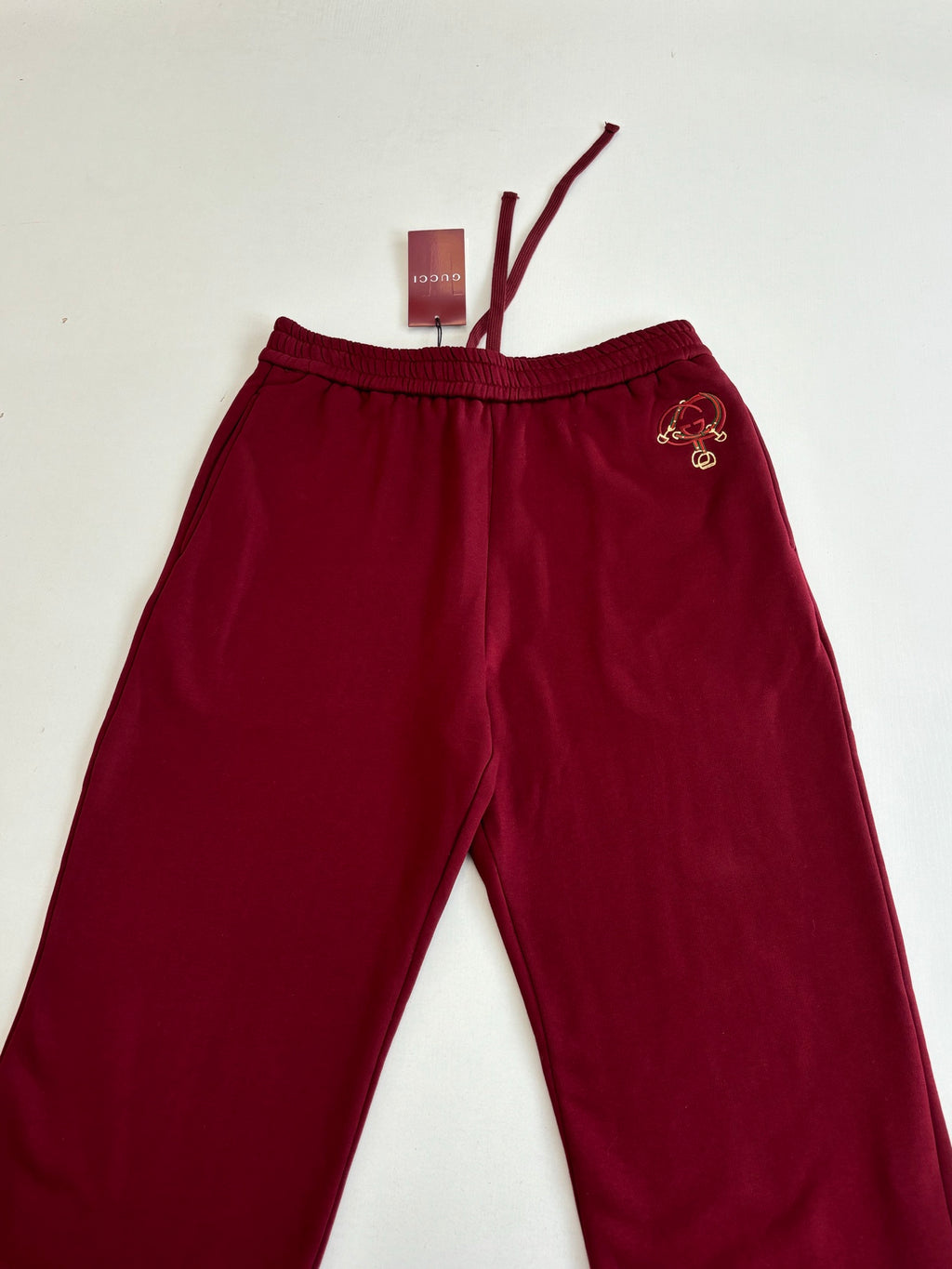 Burgundy pants with elastic waistband and embroidered side crest logo