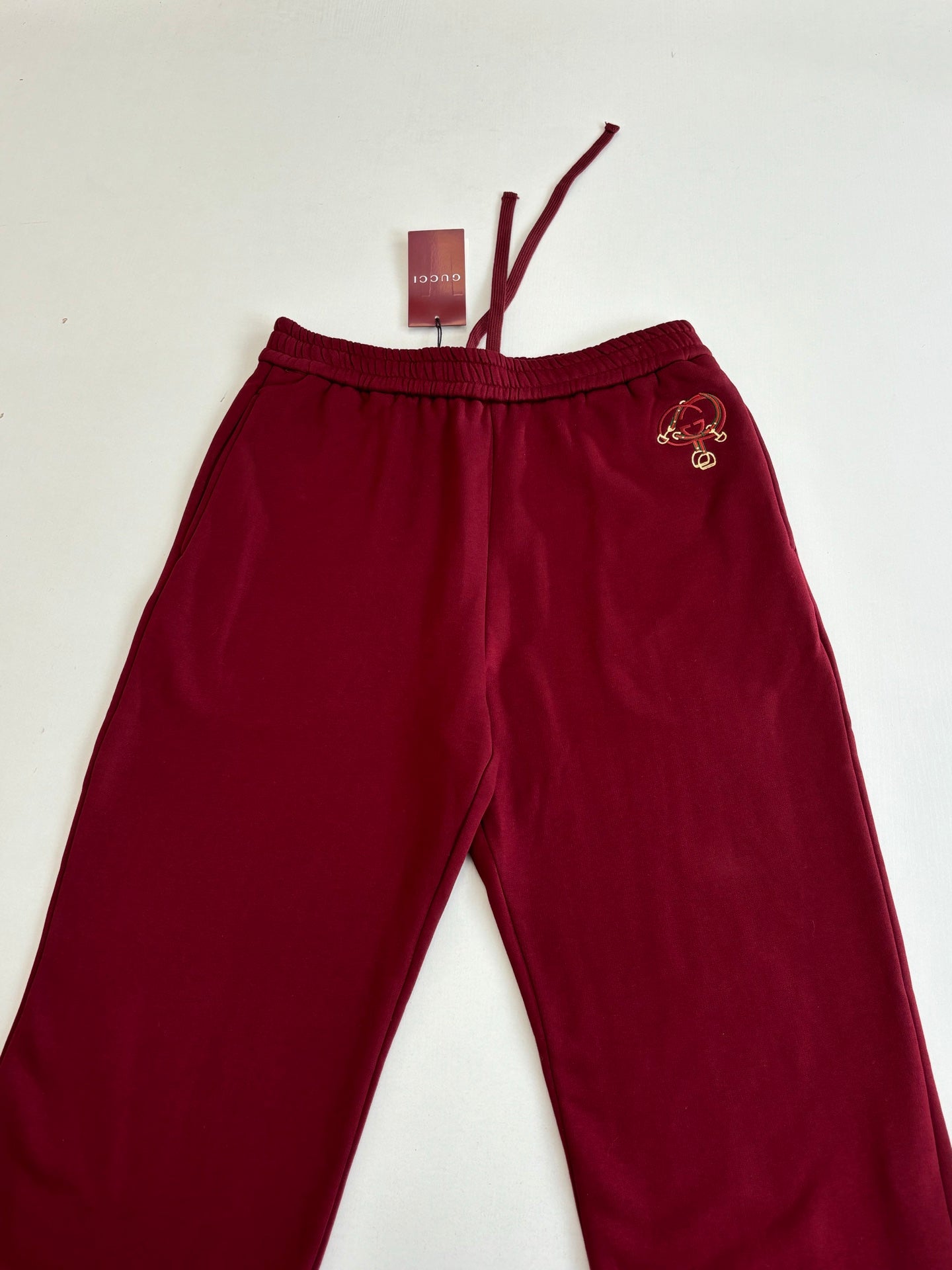 Burgundy pants with elastic waistband and embroidered side crest logo