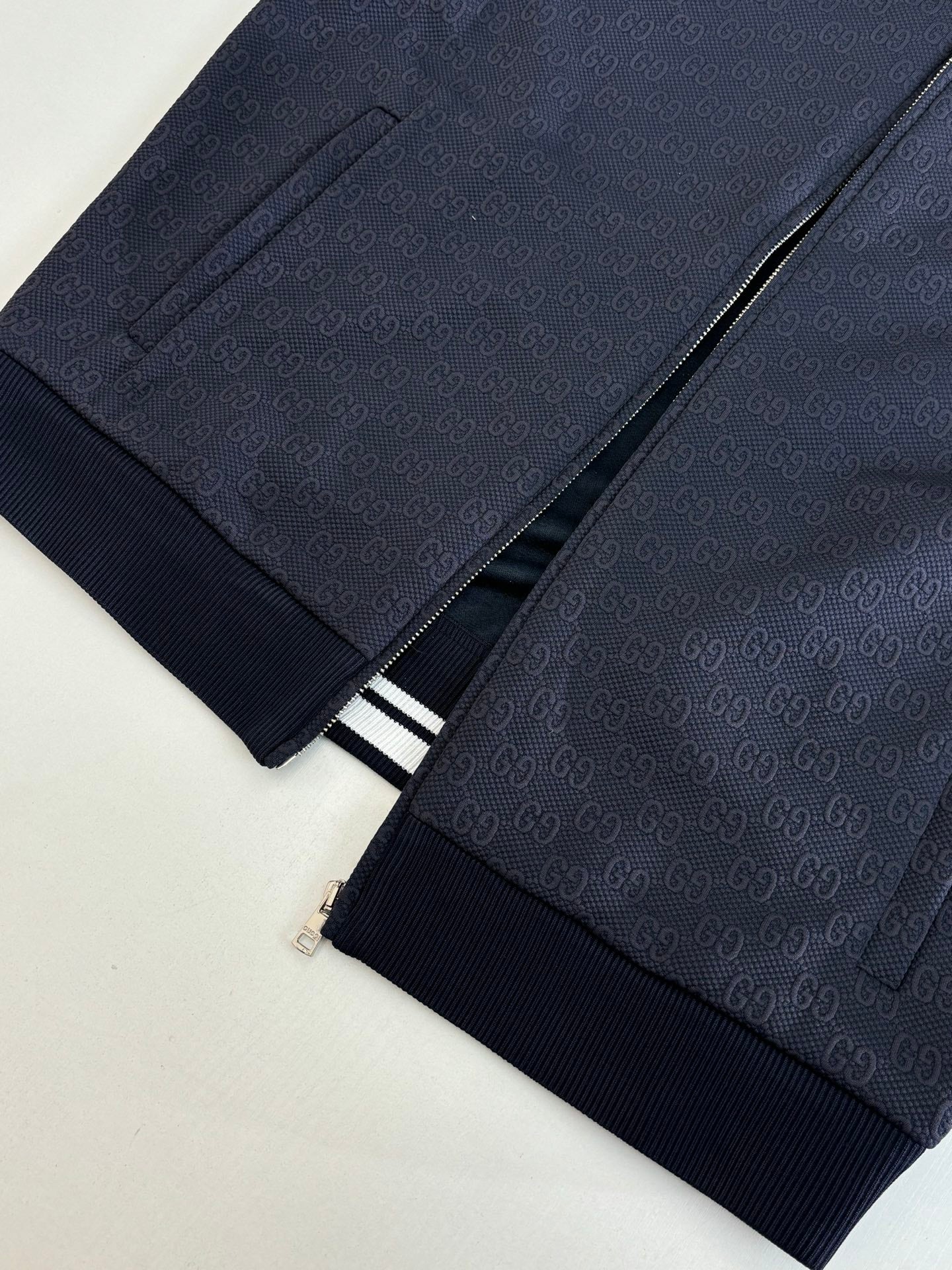 Navy Gucci track pants with front pocket and white striped waistband