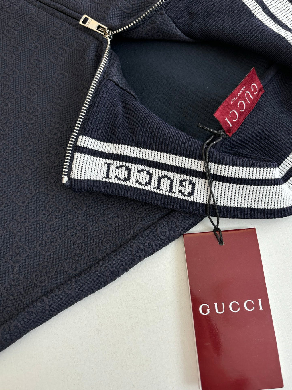 Navy Gucci track jacket interior with red logo patch and zipper