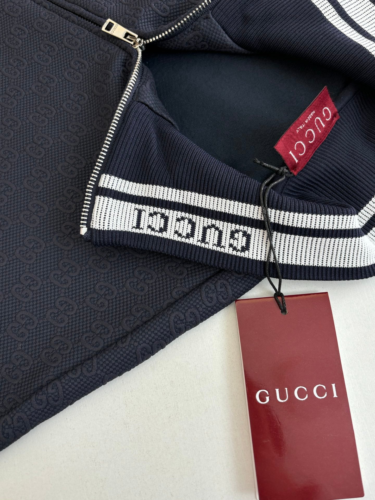 Navy Gucci track jacket interior with red logo patch and zipper