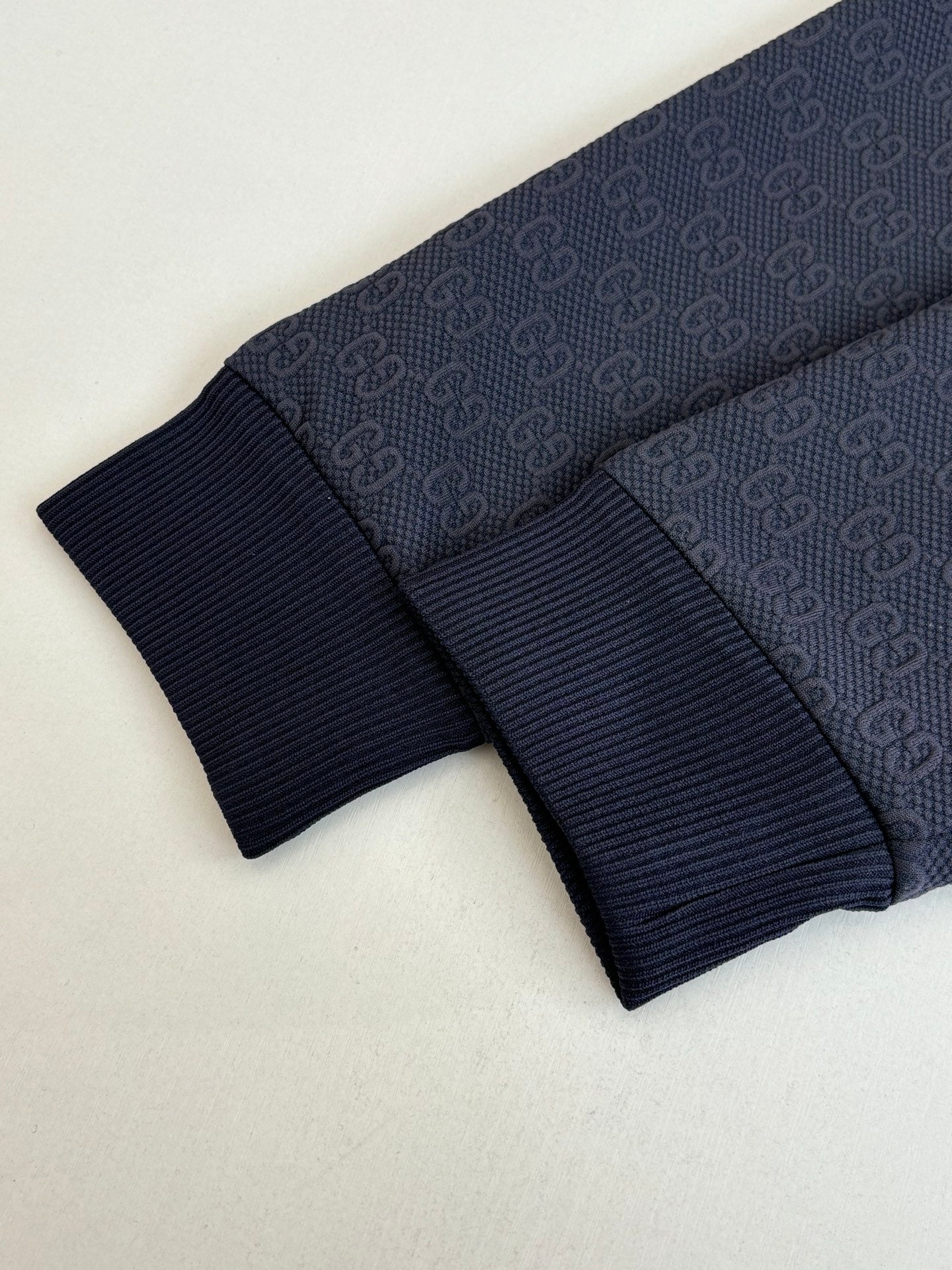Navy ribbed knit cuffs with dark monogram pattern fabric band