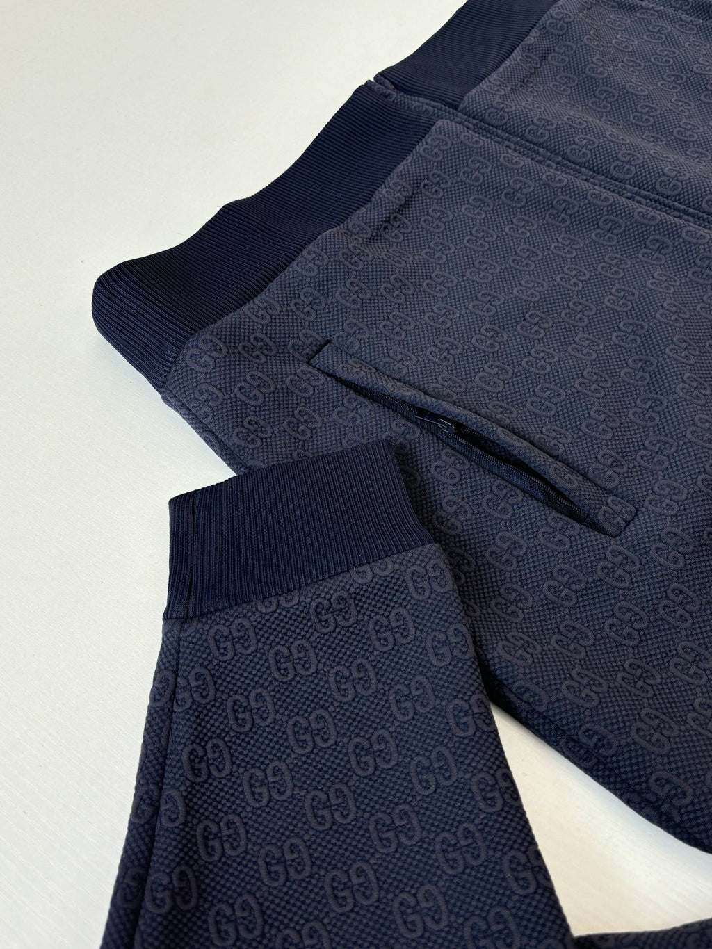 Navy Gucci track pants with subtle monogram pattern