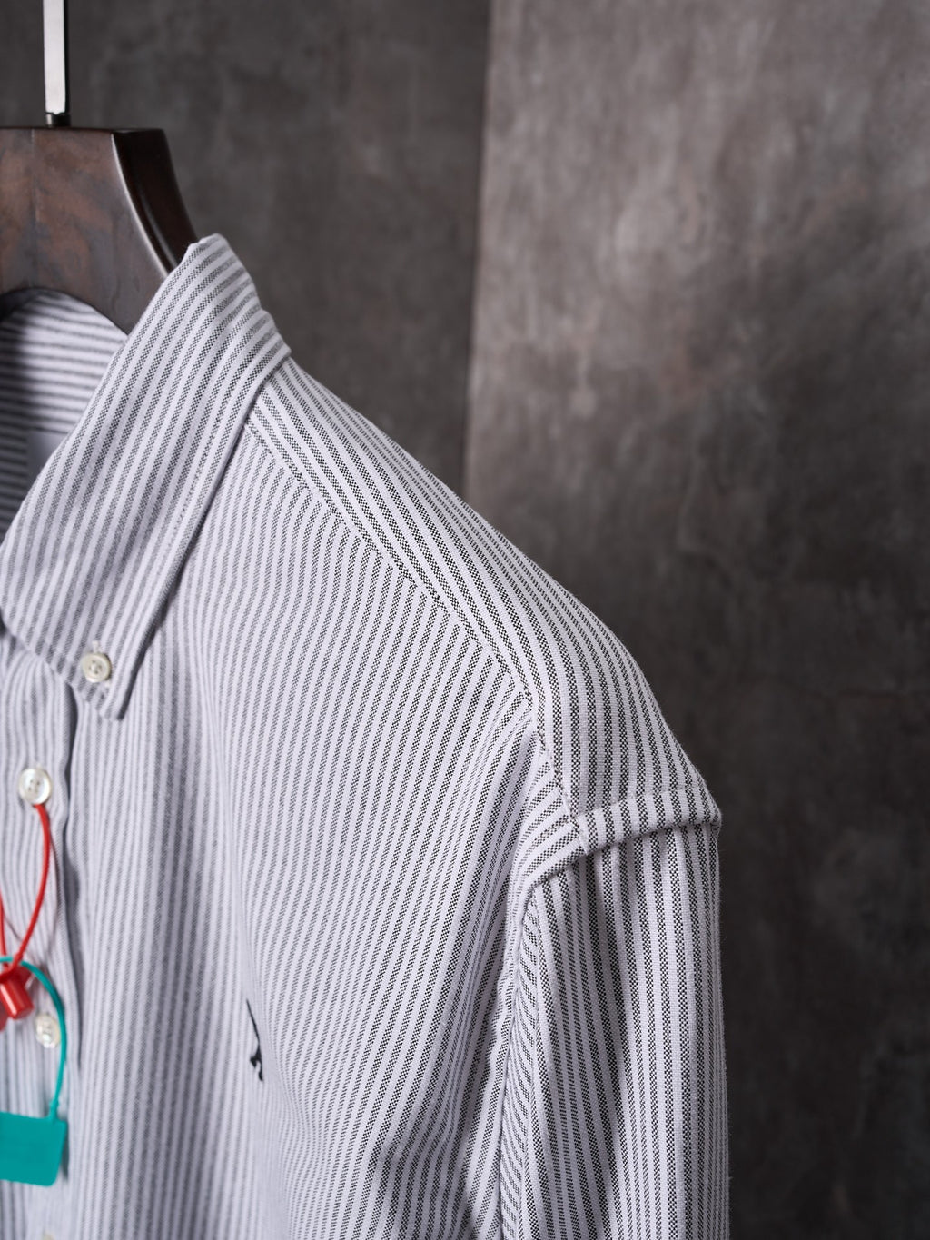 Striped button-up shirt shoulder and sleeve with gold button detail