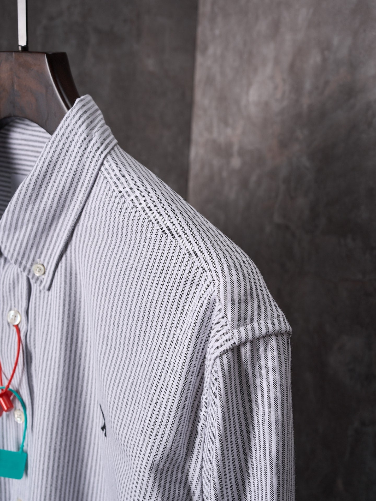 Striped button-up shirt shoulder and sleeve with gold button detail