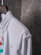 Striped button-up shirt sleeve and shoulder seam in light blue and white