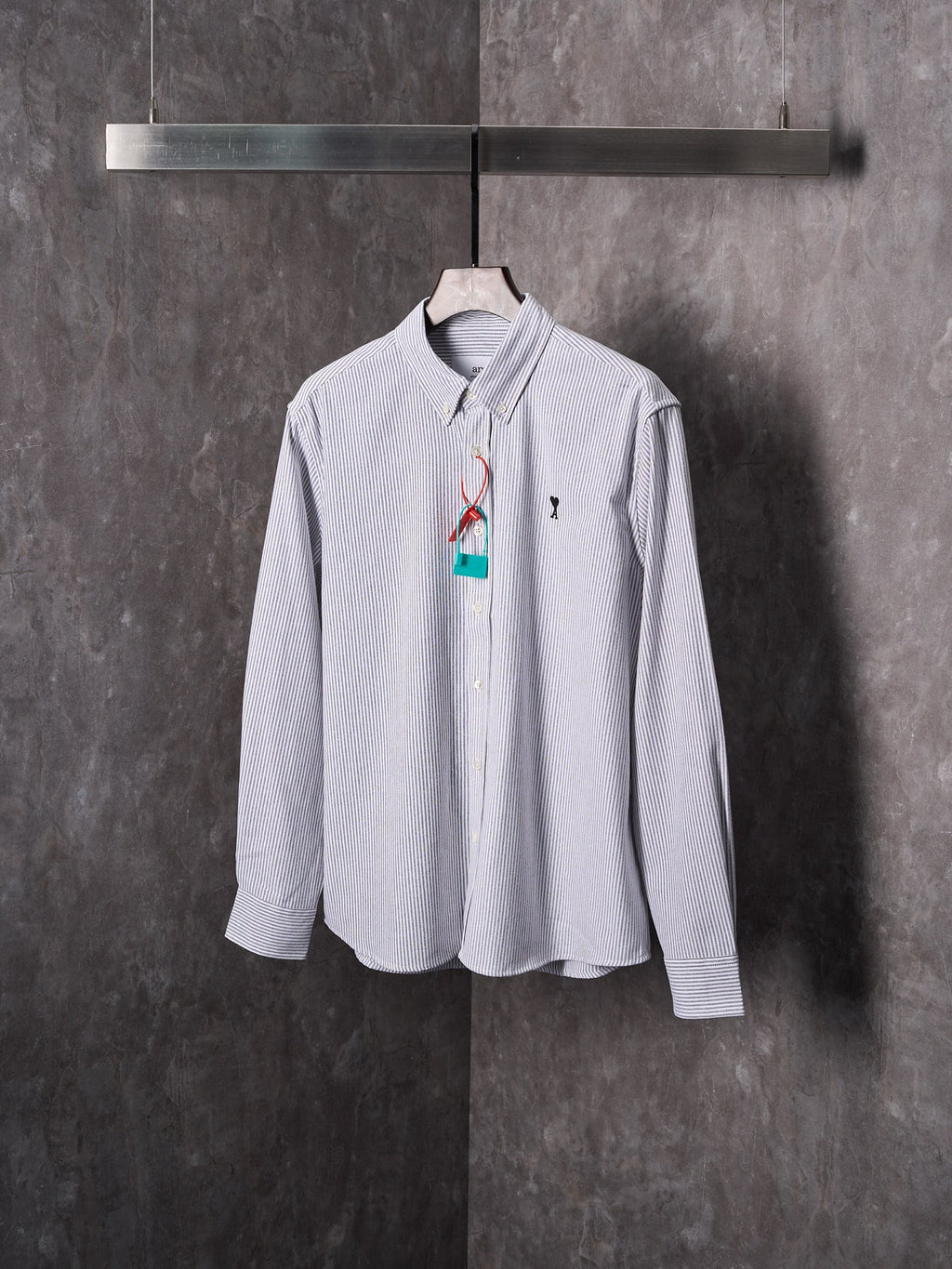 Striped button-up shirt with heart A emblem and colorful hanging tag