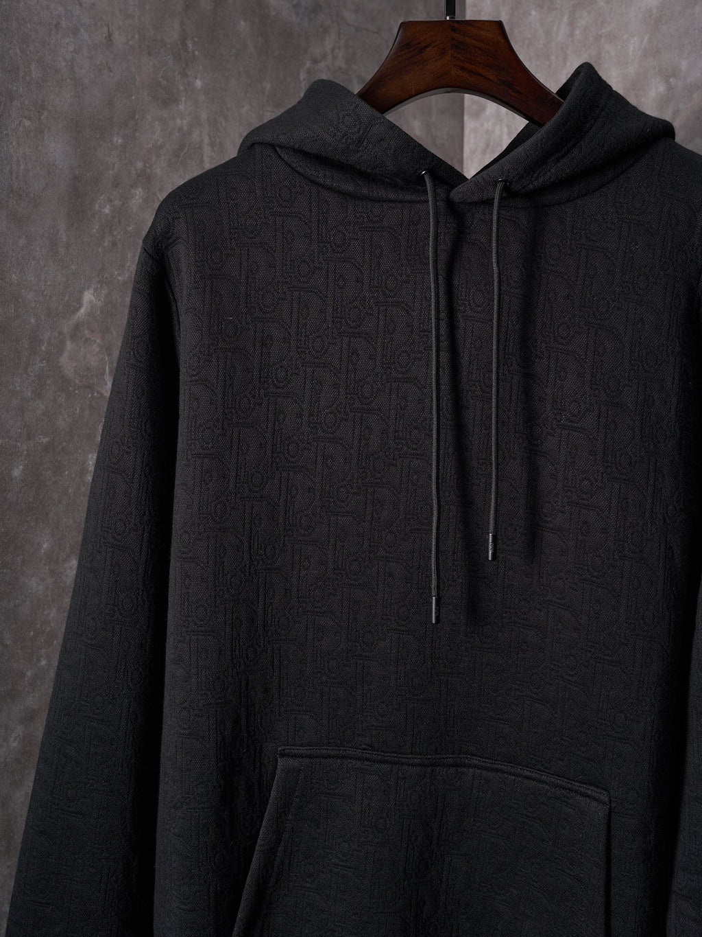 Black Dior zip-up hoodie with hood, drawstrings, and front pocket