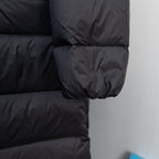 Long puffer jacket quilted sleeve with elastic cuff, dark fabric.
