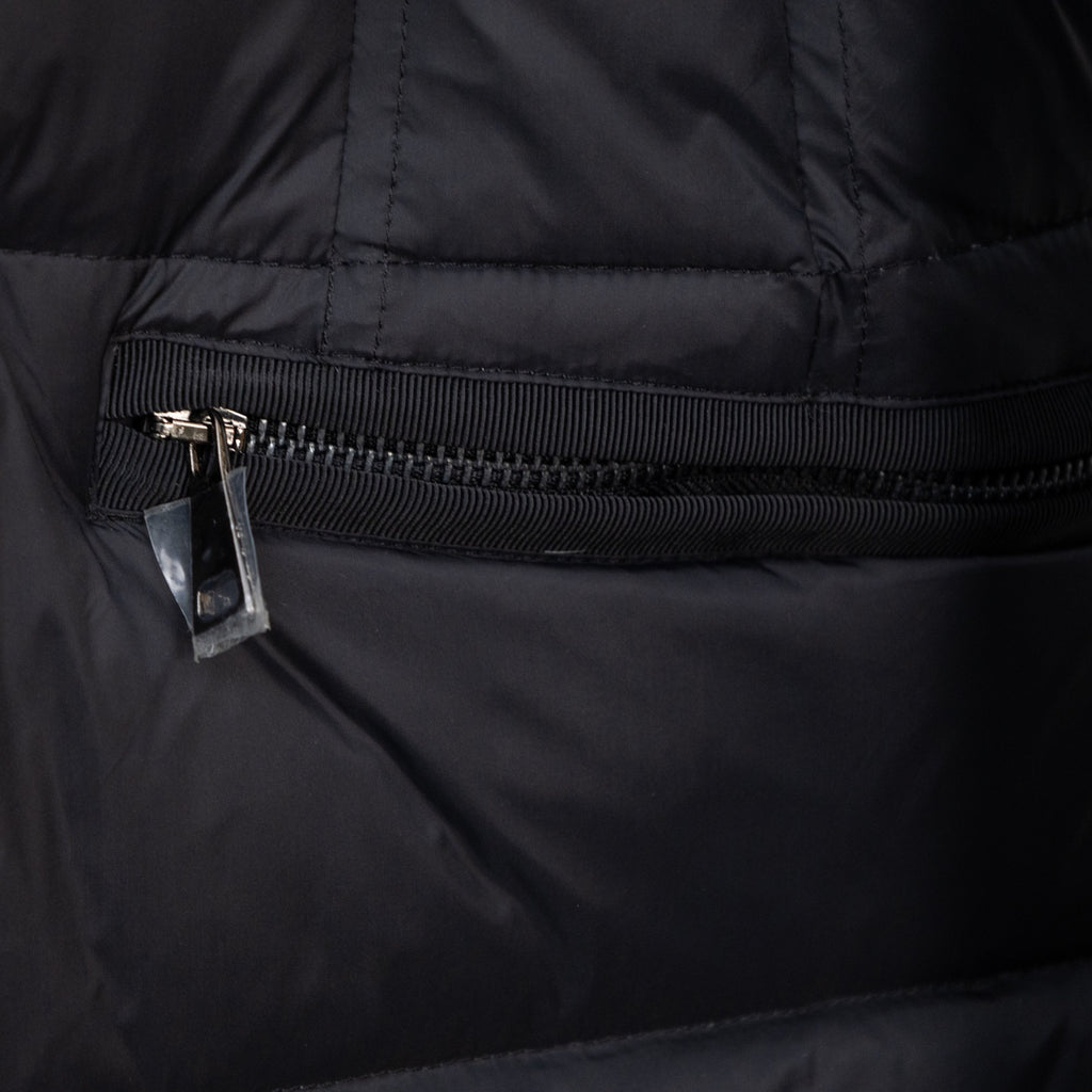 Long puffer jacket front zipper and ribbed storm flap, dark outer fabric.