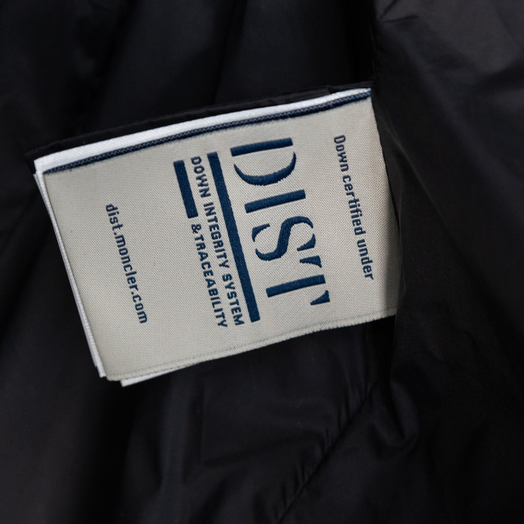 Long puffer jacket inner label with blue text and 'Down Certified' logo.