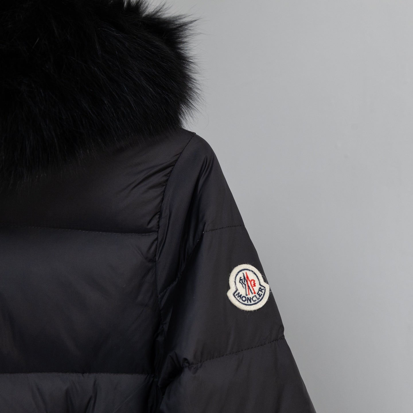 Moncler long puffer coat sleeve patch and dark puffer fabric