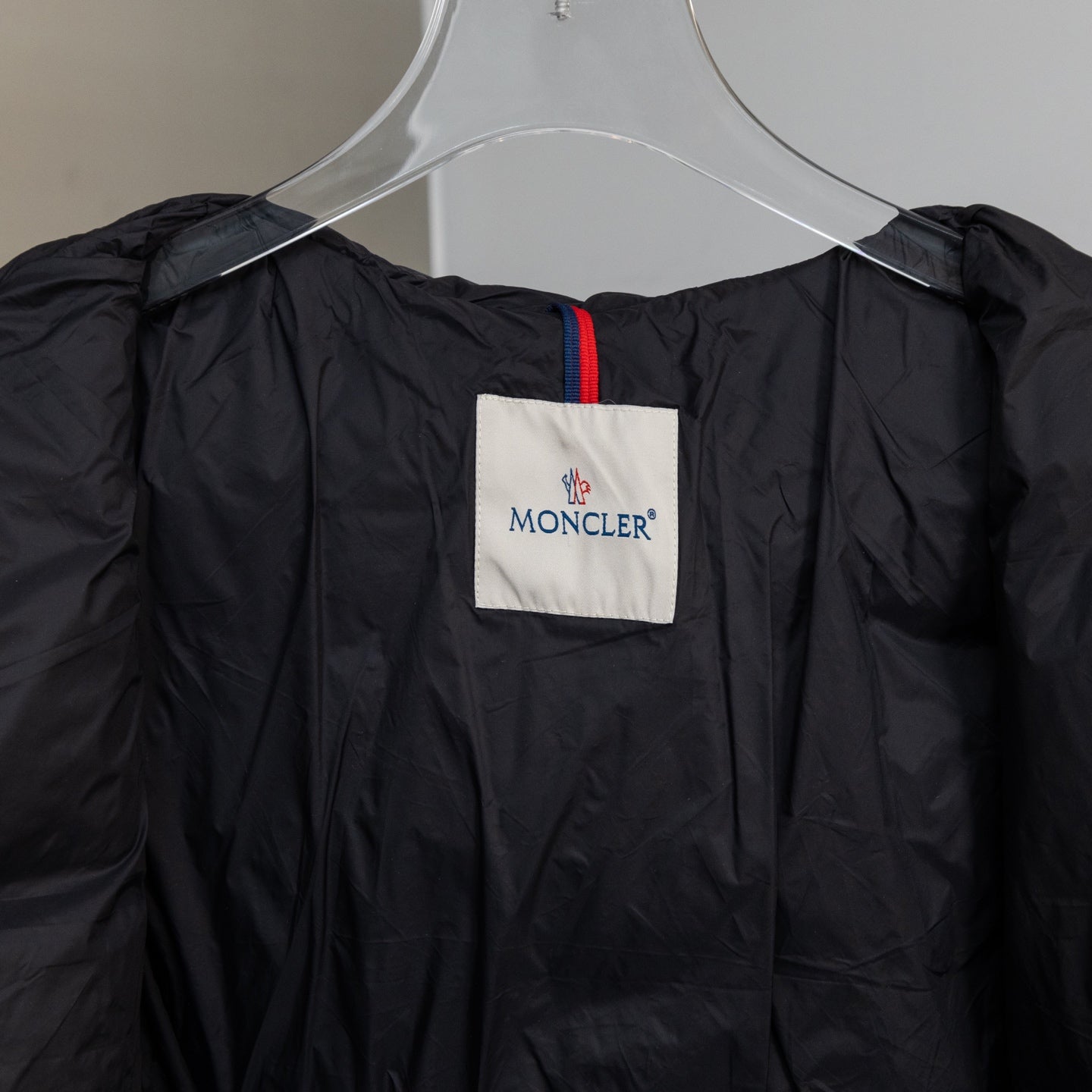 Moncler long puffer coat neckline label with contrast trim, dark fabric