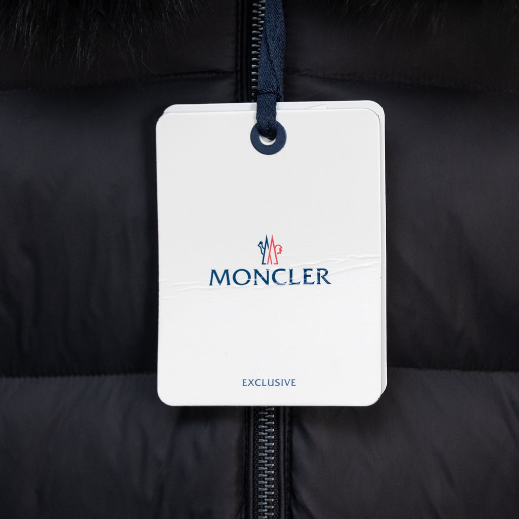 Moncler garment tag on long puffer coat zipper, dark fabric
