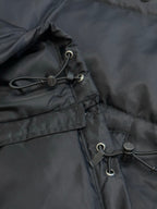 Prada dark puffer jacket close-up of hood drawstring with metal toggles